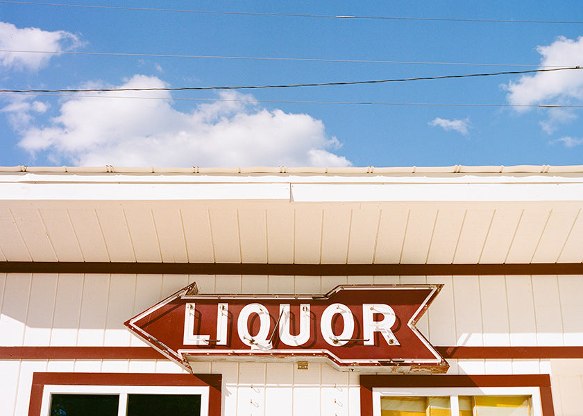 Vintage foto bord 'LIQUOR' tegen blauwe lucht